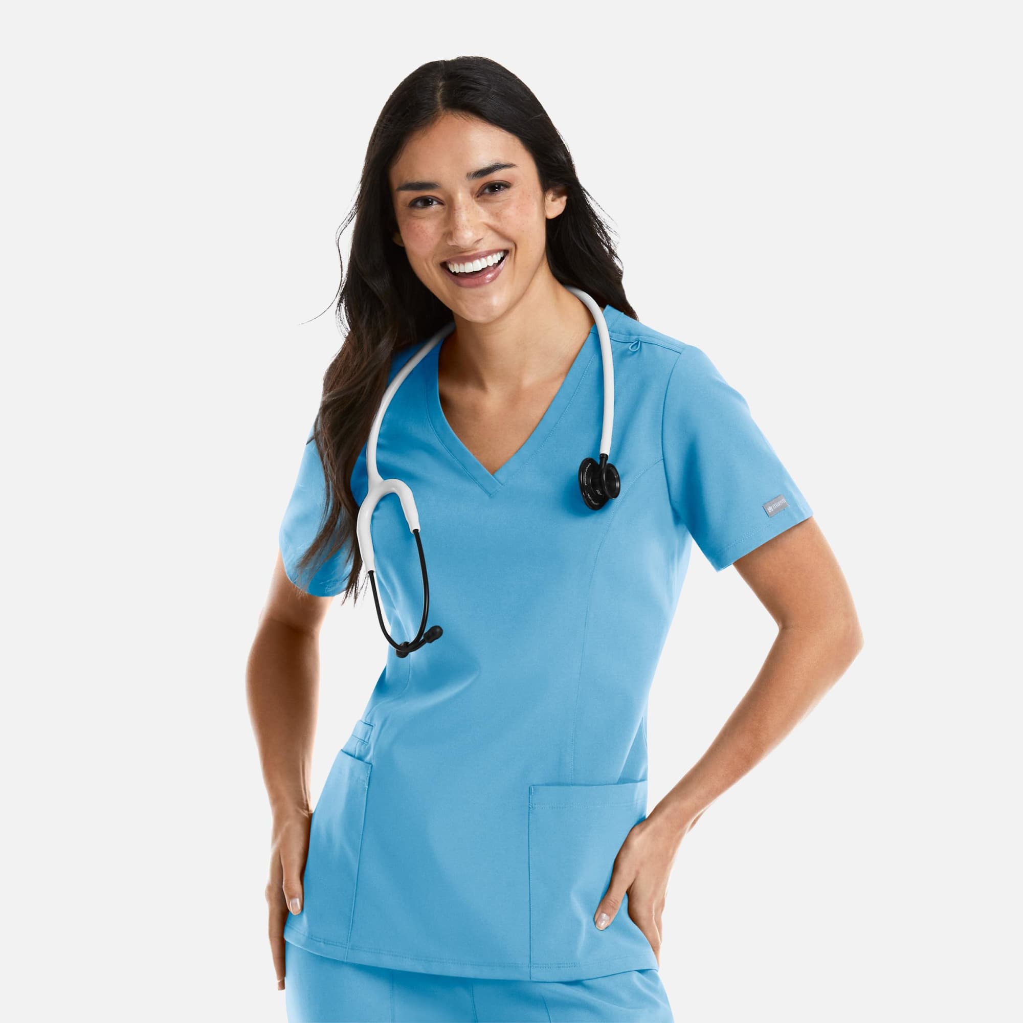 A woman models a blue double V-neck top with a stethoscope around her neck, featuring pockets and a logo. Momentum Womens Double V-Neck Top - Image 1