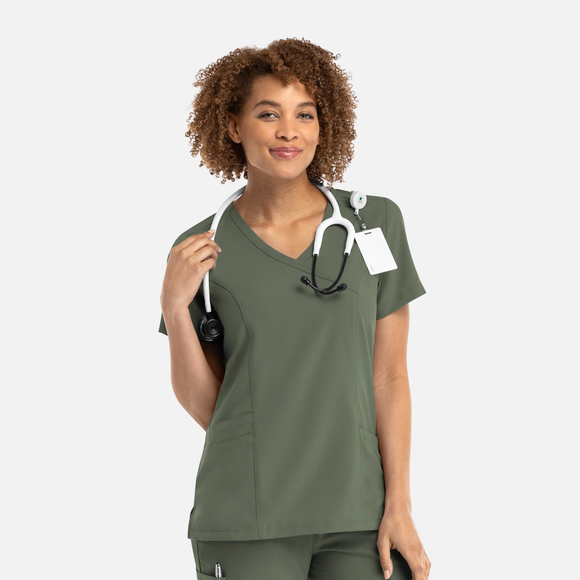 A mock wrap top in olive green, featuring a V-neck and fitted design, with a stethoscope around the model's neck. Momentum Womens Mock Wrap Top - Image 1
