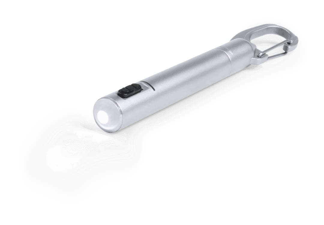 A silver pen torch with a carabiner clip and a button for activation. It emits a bright light from its end. Krujer Pen Torch - Image 1
