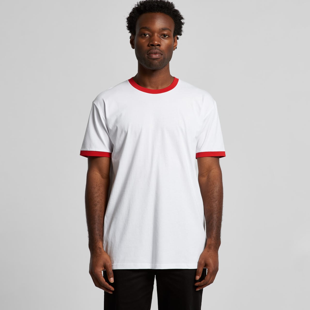 A white t-shirt with red ringer sleeves, featuring a logo on the front. Staple Ringer Tee - Image 1