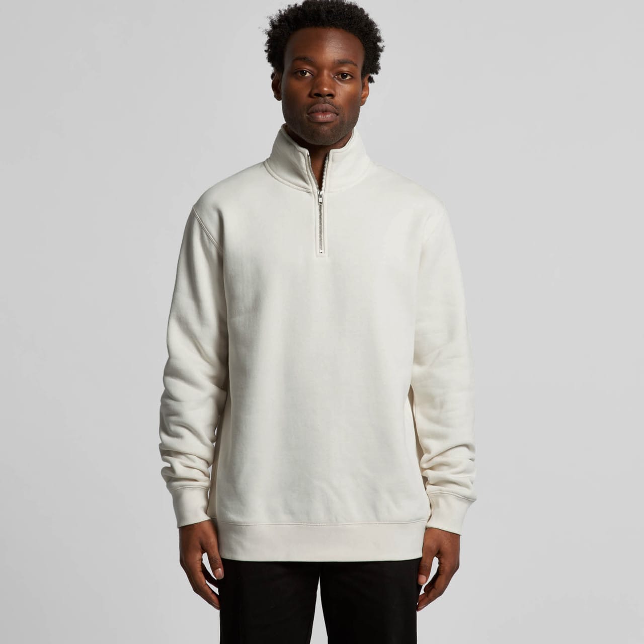 A man is wearing a cream-coloured half zip crew jumper with a relaxed fit, featuring a stand-up collar. Stencil Half Zip Crew - Image 1