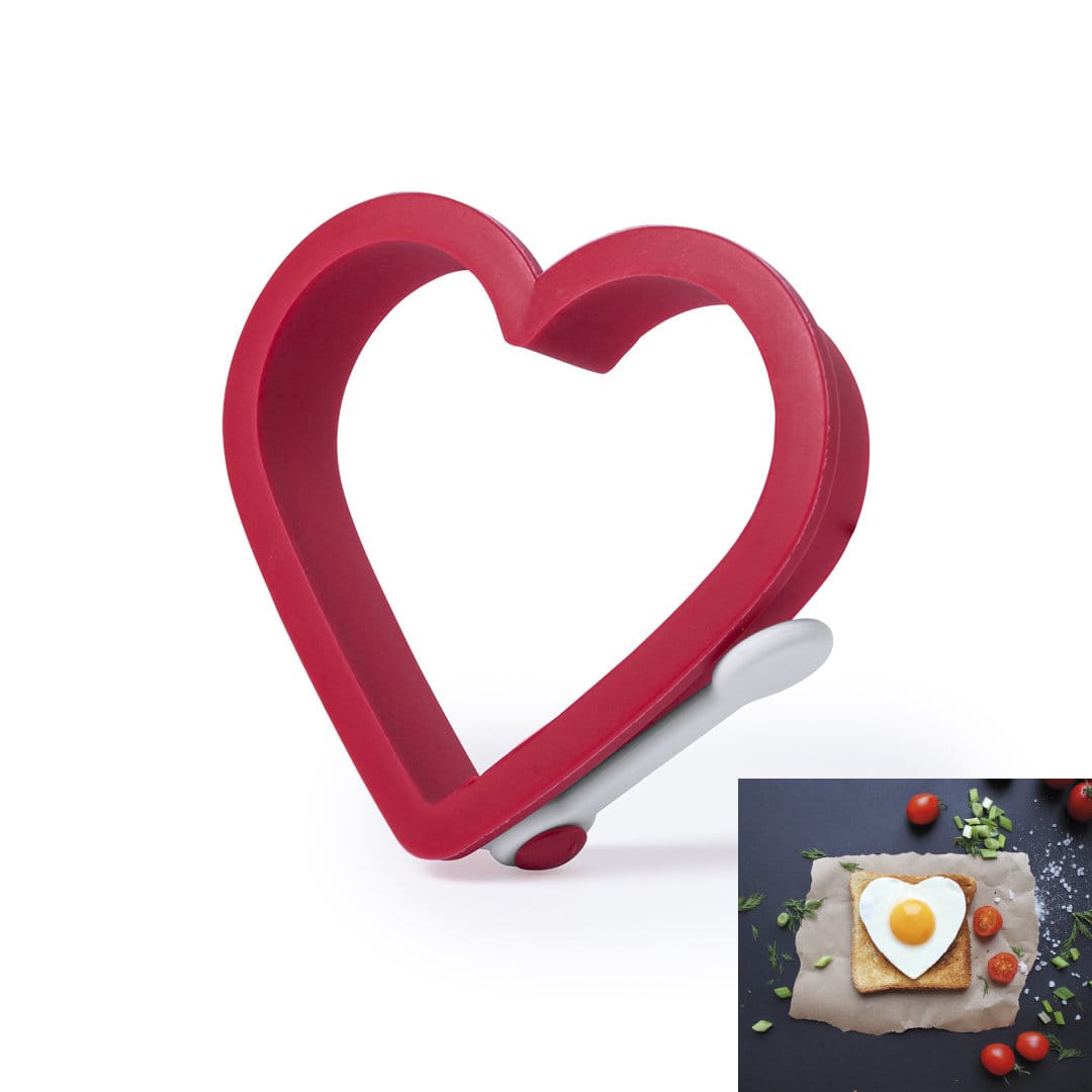 A heart-shaped mould in red plastic with a white handle, designed for cooking or food presentation. Baldix Mold - Image 1