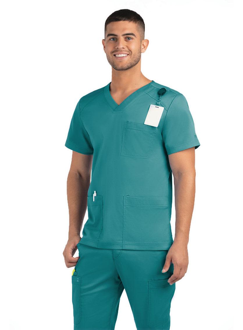 A men's teal v-neck top featuring three pockets, with a tag attached, modelled by a smiling man. Matrix Mens 3 Pocket V-Neck Top - Image 1