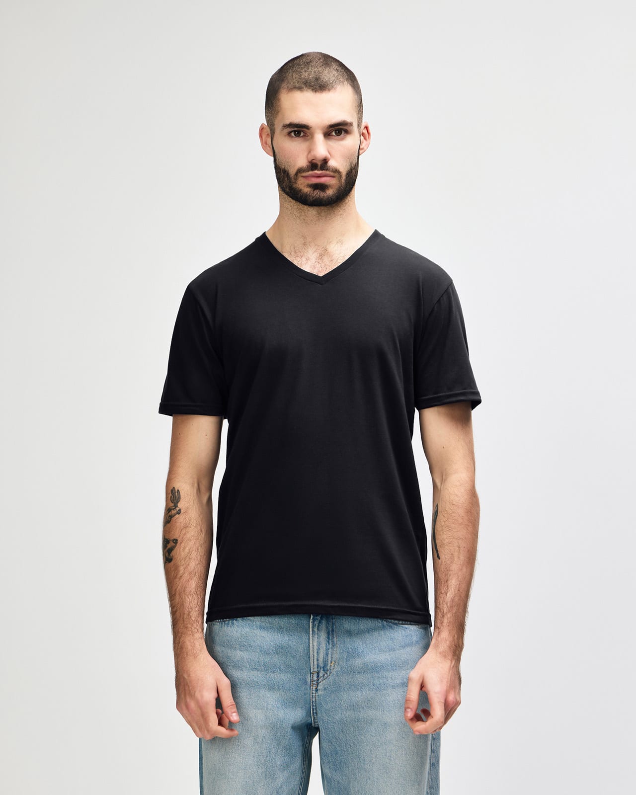 A black Gildan Softstyle adult v-neck t-shirt displayed on a model. The shirt features a branding logo. Gildan Softstyle Adult V-Neck T-Shirt - Image 1