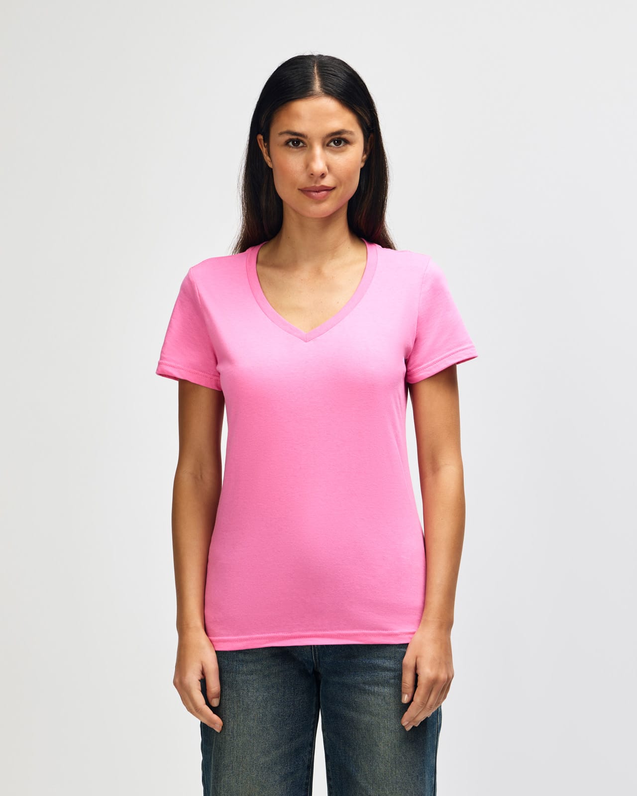 A pink ladies' V-neck T-shirt featuring a logo, displayed on a model with straight hair. Gildan Softstyle Ladies' V-Neck T-Shirt - Image 1