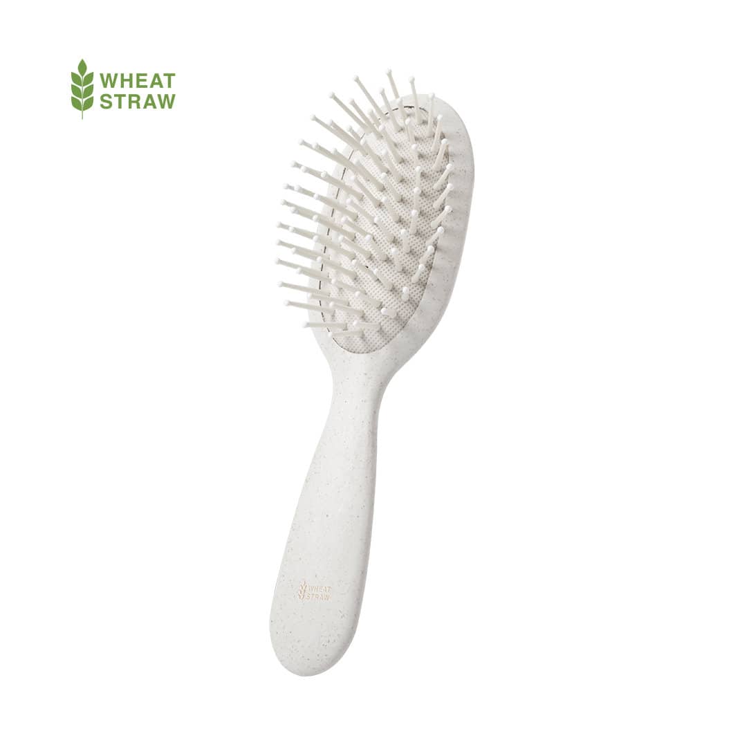 A hairbrush featuring a pale white design with flexible bristles and a textured handle. It has a logo. Dantel Hairbrush - Image 1