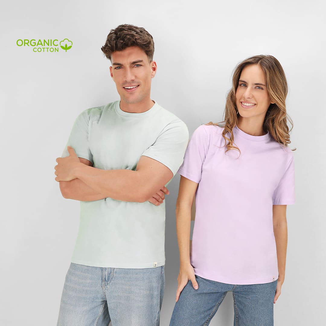 Pair of adults wearing t-shirts in light green and lavender, made from organic cotton. One shirt features a logo. Guim Adult T-Shirt - Image 1