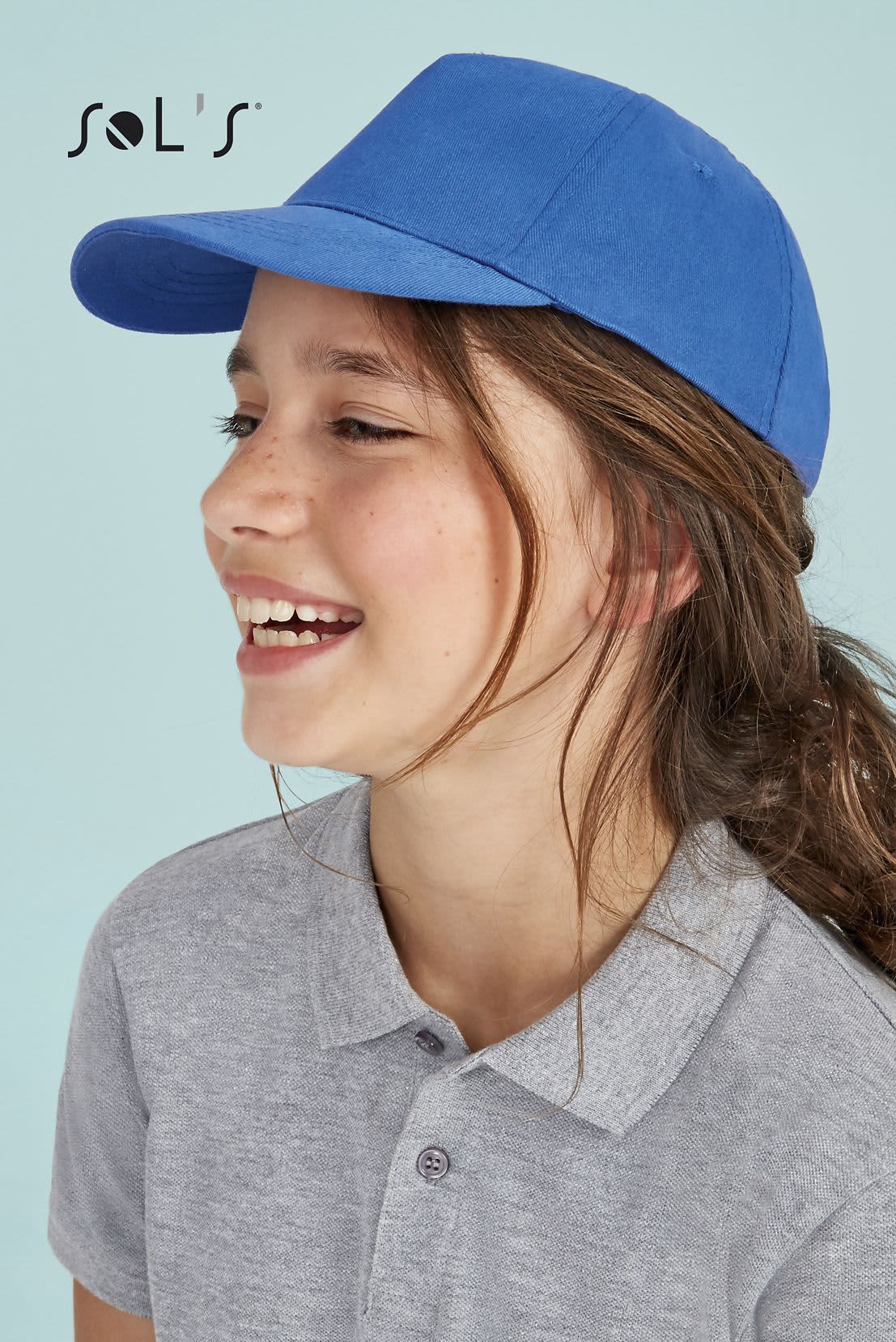 A blue five-panel cap made of light brushed cotton, worn by a smiling child. The cap features a logo. Cap KIDS 5 panel light brushed cotton SUNNY - Image 1