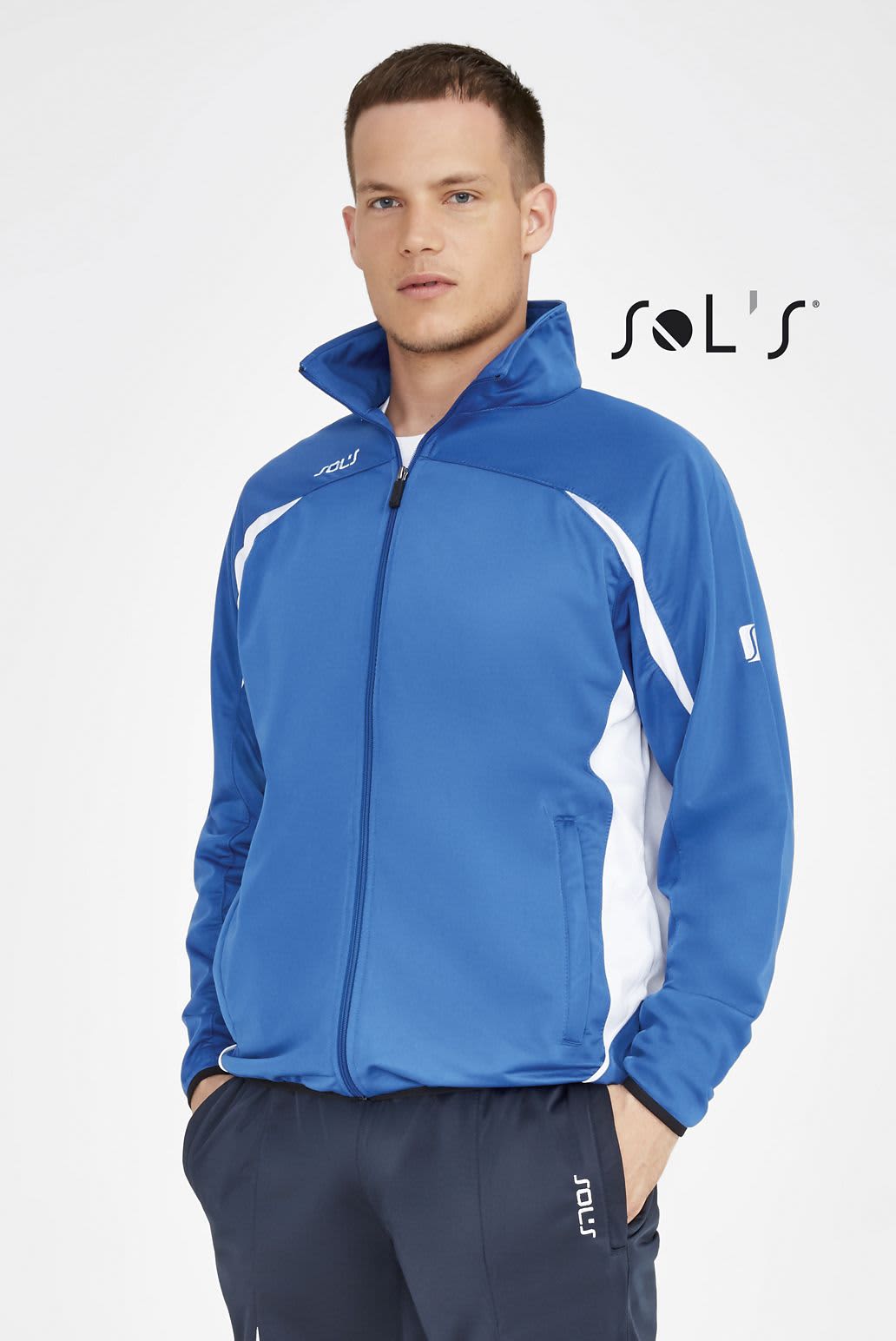 A blue and white tracksuit jacket with a zip-up front and stand-up collar, featuring a branding logo. TRACKSUIT Adult club - Image 1