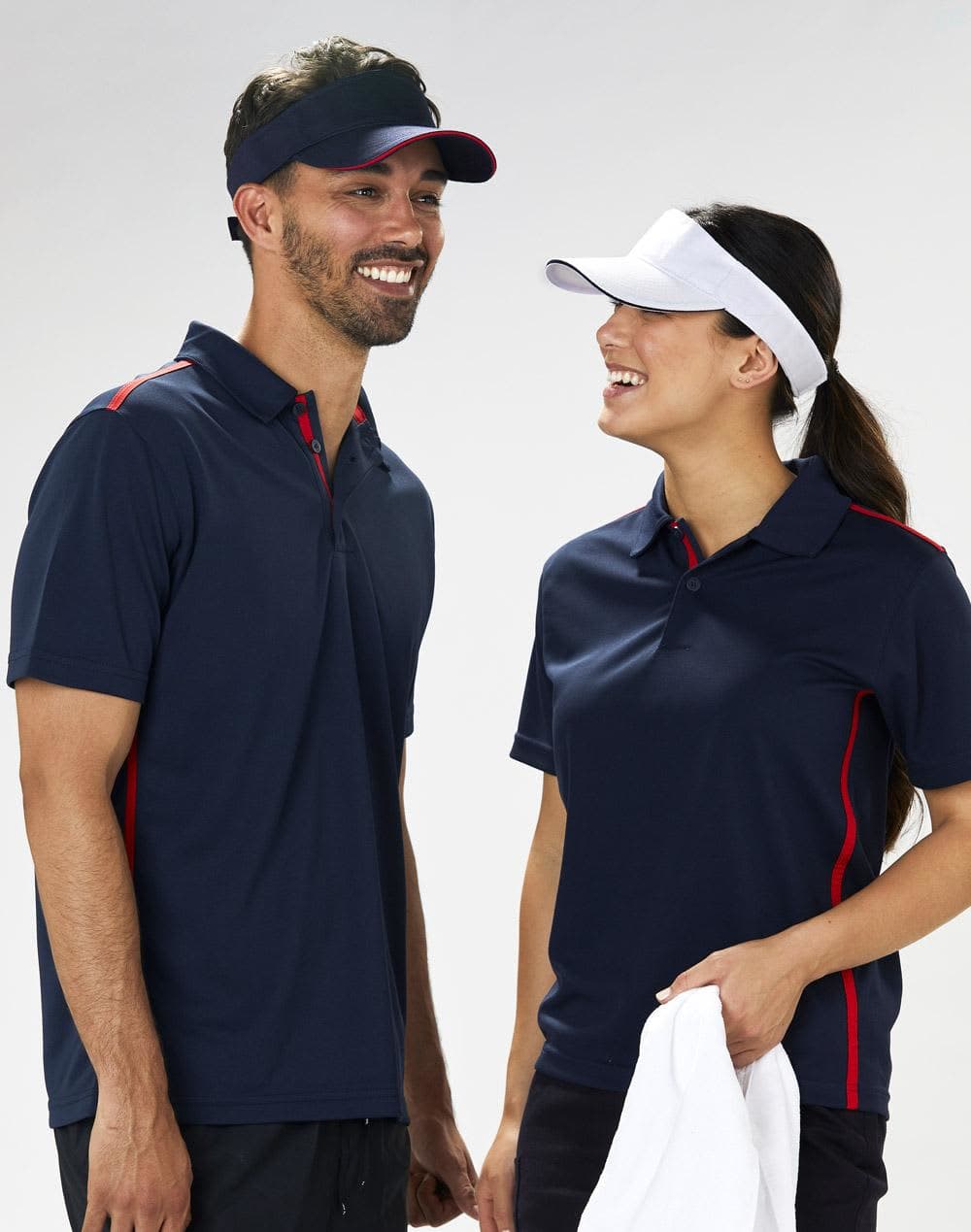 A navy visor with a contrasting white band, worn by a smiling man and woman in matching polo shirts. Polo twill visor - Image 1