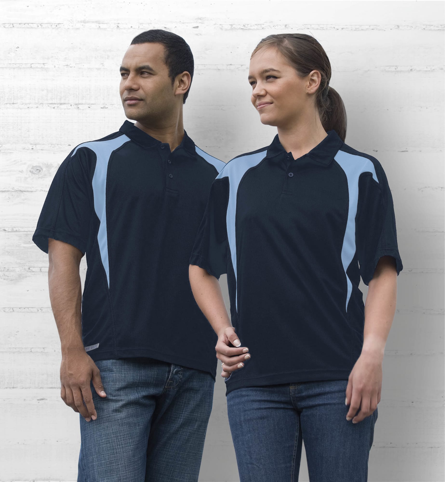 A navy blue polo shirt with light blue spliced design, featuring a logo on the chest, displayed on male and female models. Dri Gear Spliced Zenith Polo - Image 1