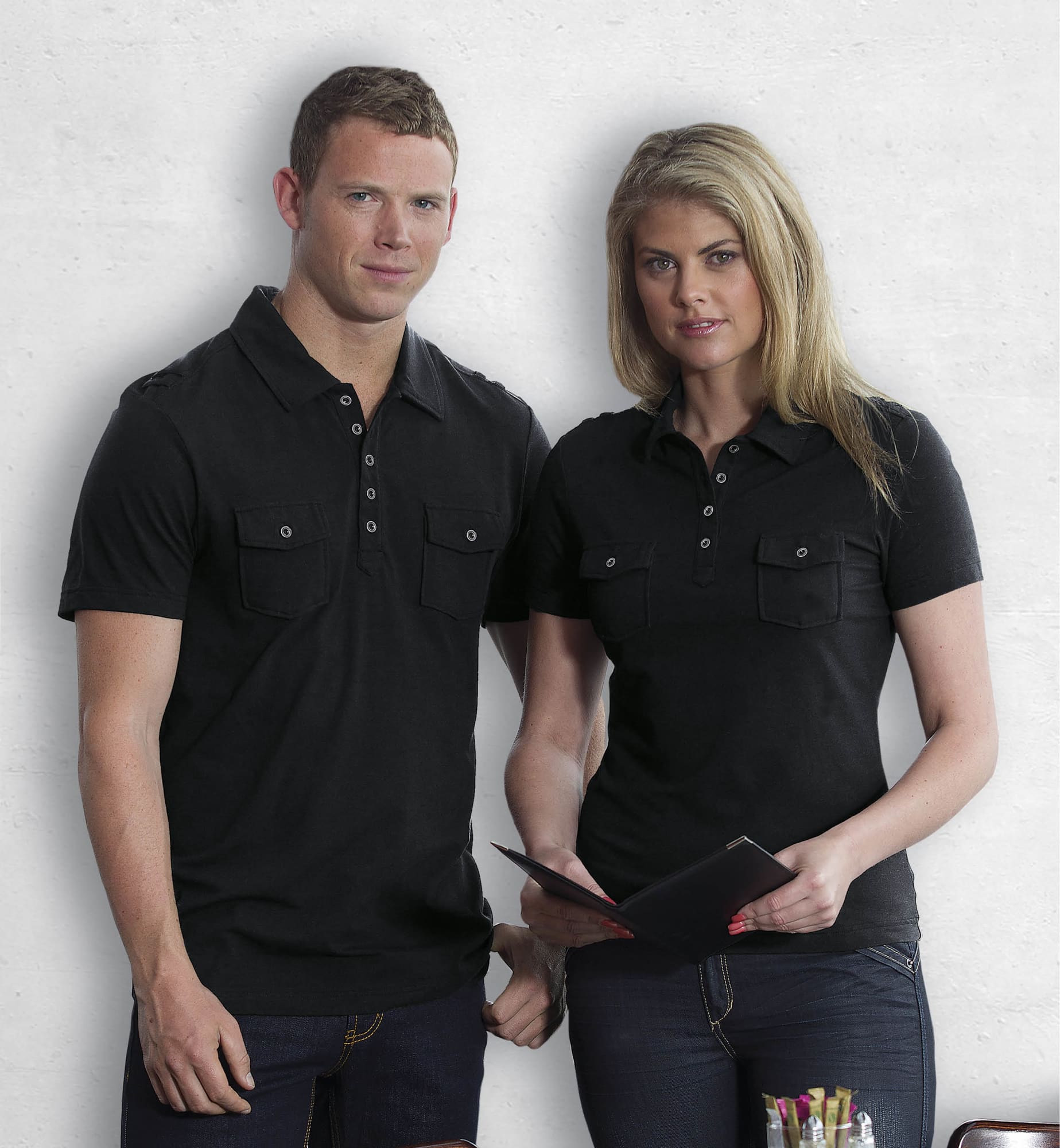 A black women's polo shirt featuring two chest pockets and a classic collar, displayed by a model. Fusion Polo - Womens - Image 1