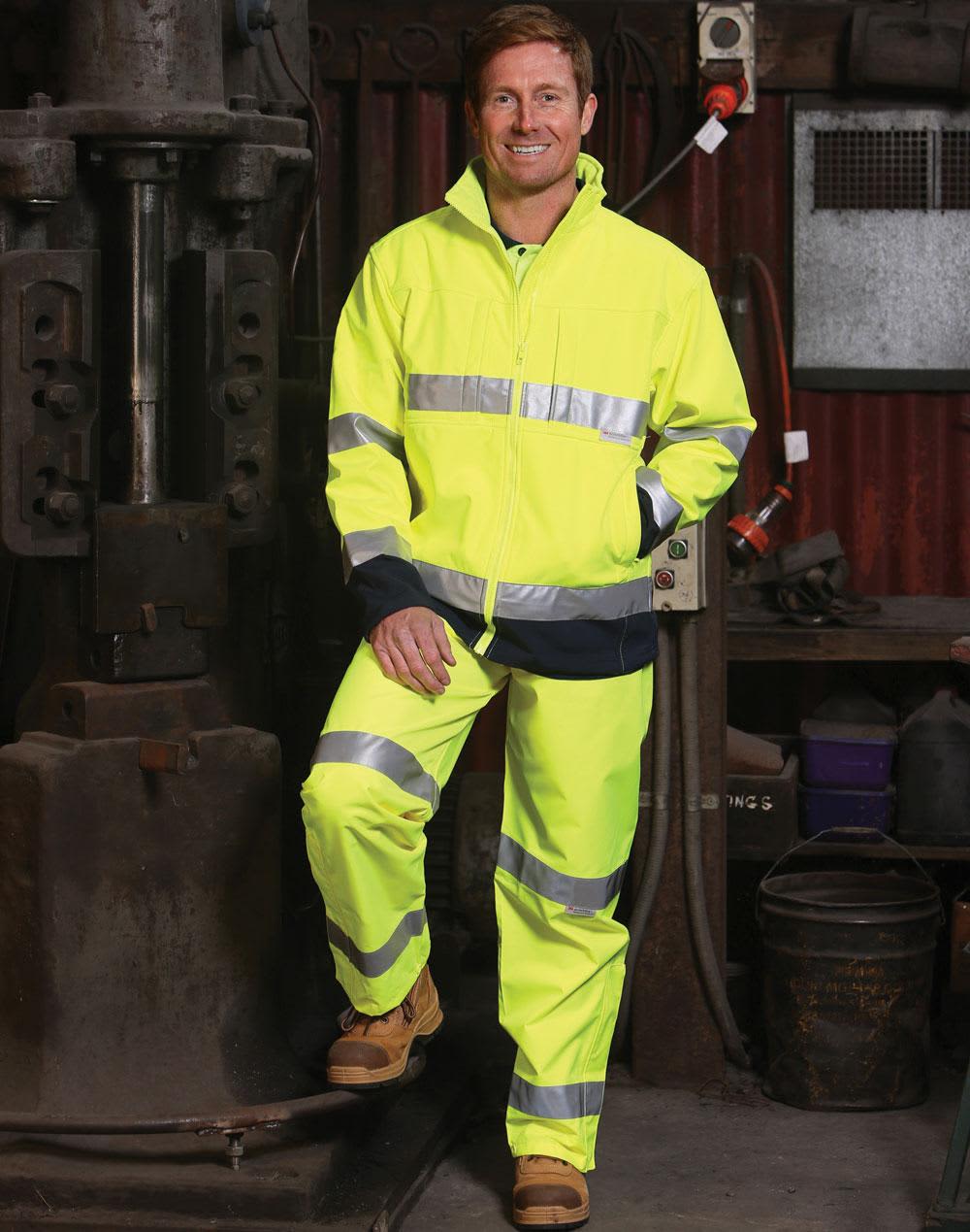 Hi-Vis safety pant in yellow with reflective 3M tape, paired with a matching jacket and work boots, set in an industrial background. Hi-Vis Safety Pant with 3M Tapes - Image 1