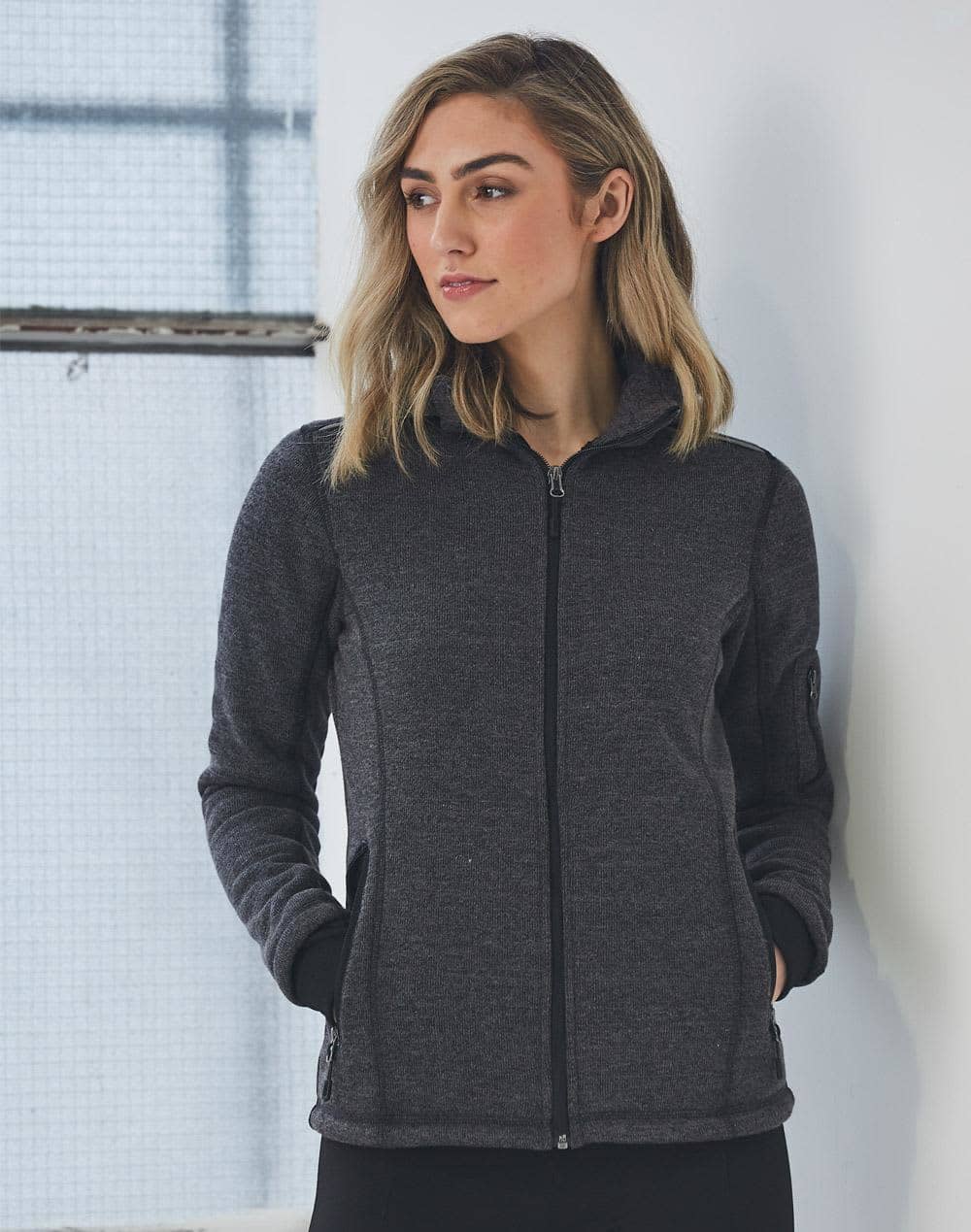 A ladies' heather bonded fleece jacket in dark grey with a zip closure and pockets. The model has a neutral expression. Ladies' Heather Bonded Fleece Jacket - Image 1