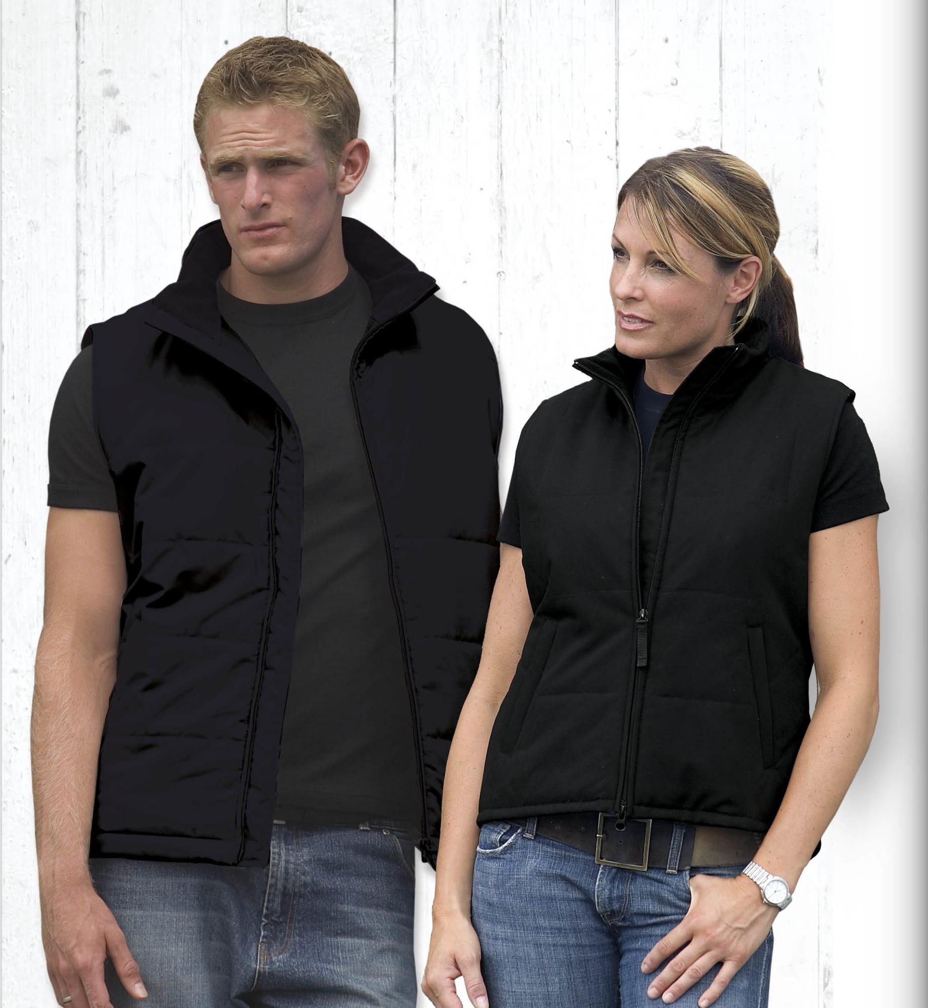 A black women's vest with a zip front and pockets, displayed on a model against a wooden background. Legacy Vest - Womens - Image 1