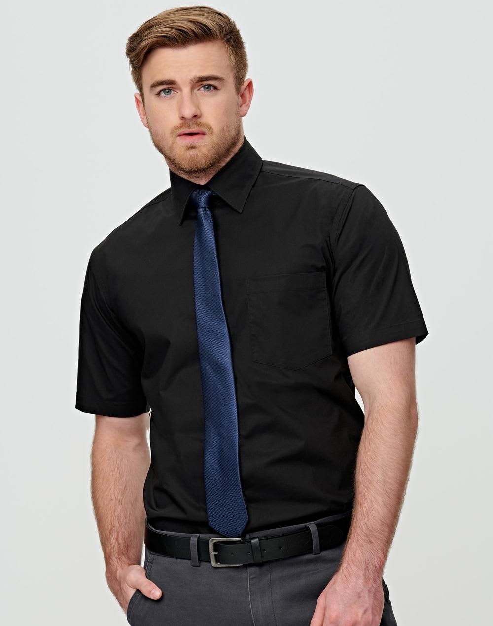 A black short-sleeve button-up shirt featuring a pocket and worn with a navy tie. The shirt has a logo. Men's Cotton/Poly Stretch S/S Shirt - Image 1