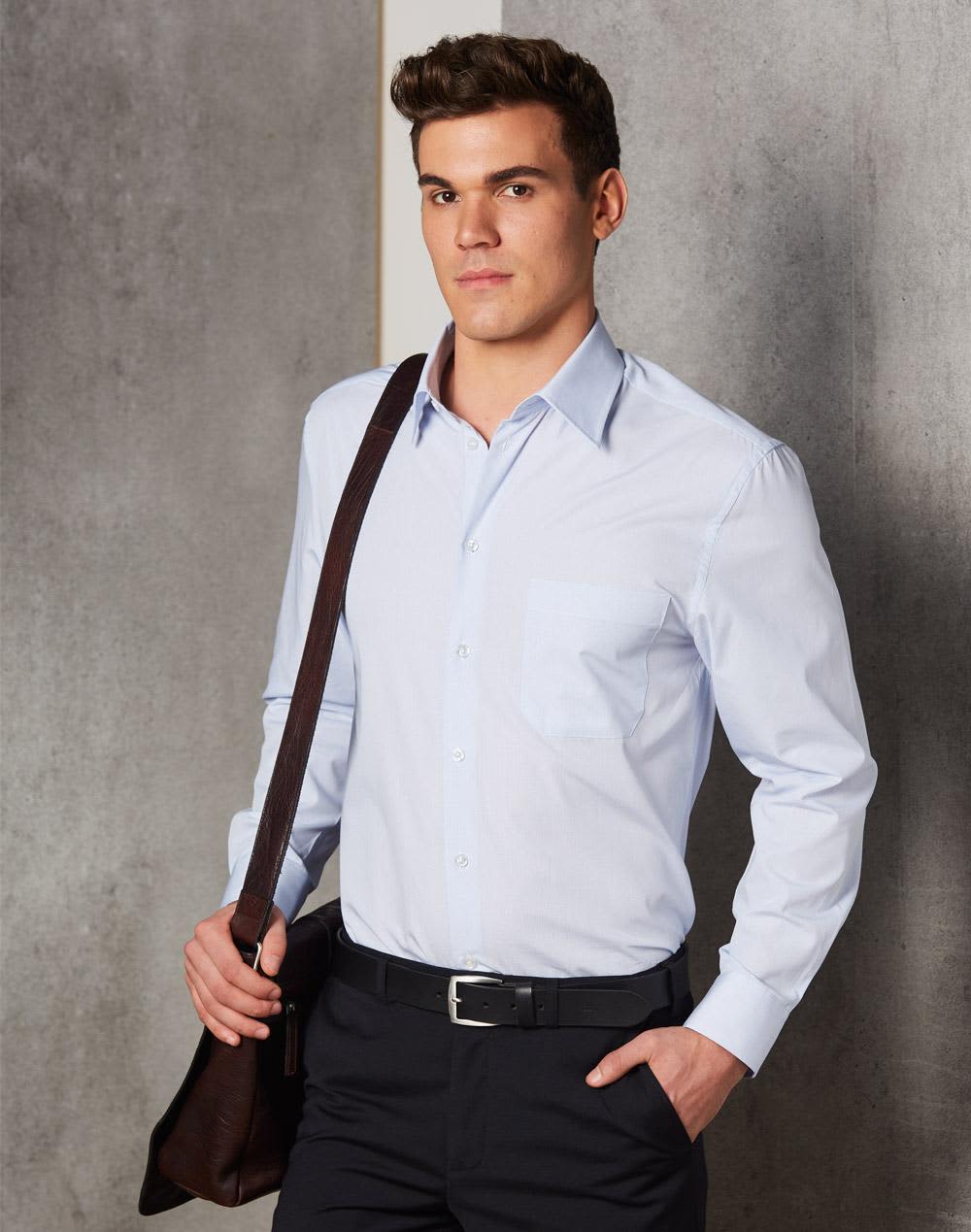 A light blue long-sleeve button-up shirt with a chest pocket, worn by a man holding a brown bag. Men's Mini Check L/S Shirt - Image 1