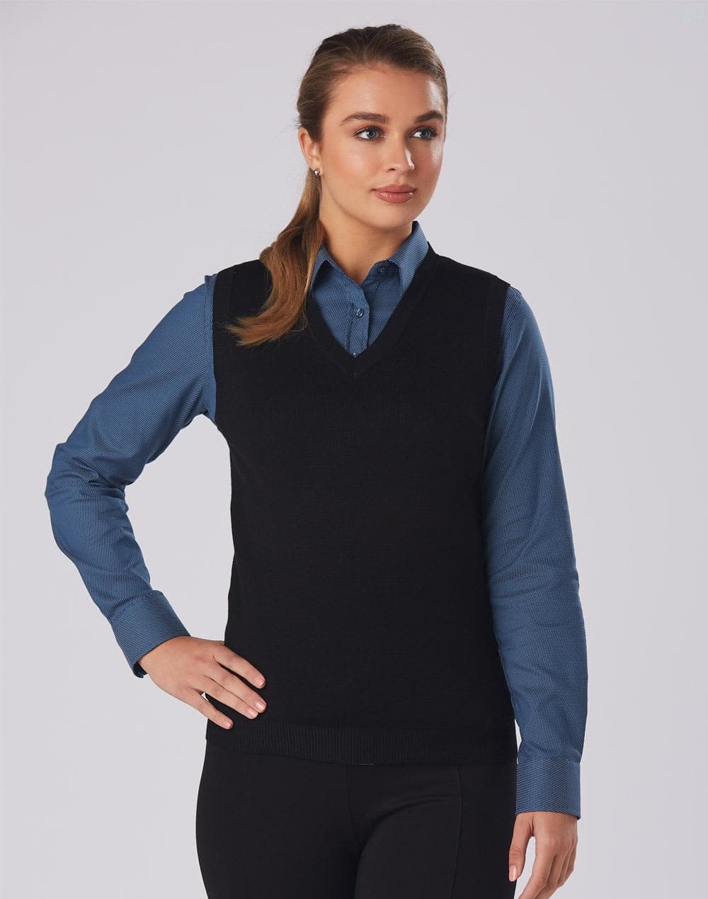 A black women's v-neck vest worn over a blue shirt, featuring a fitted design and casual style. Women's V-Neck Vest - Image 1
