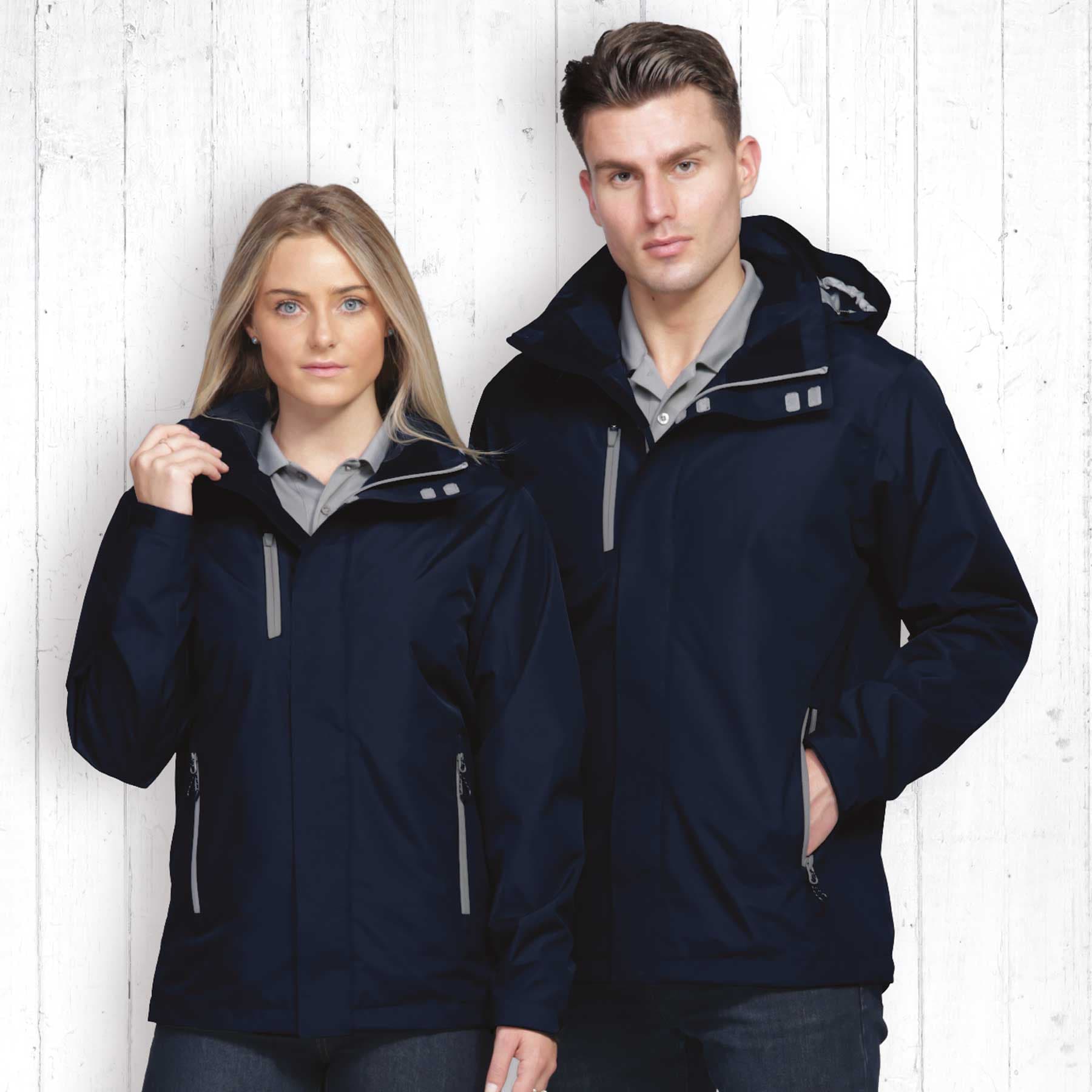 A navy soft shell jacket on a man and woman, featuring zippered pockets and a hood. The background is wooden. Nordic Jacket - Image 1