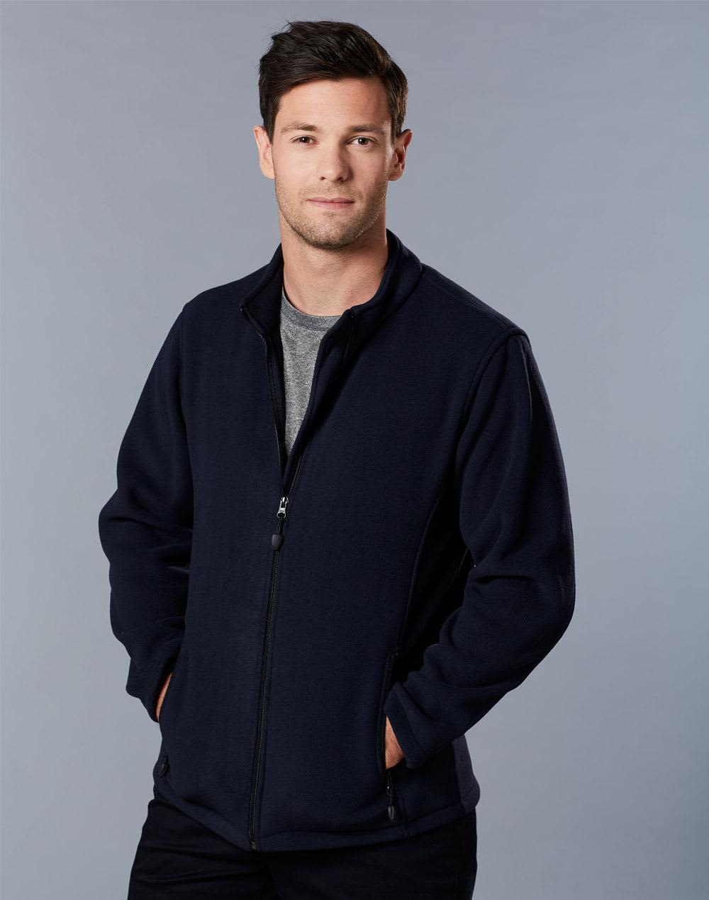 A man in a navy polar fleece jacket with a full zip, standing with hands in pockets against a grey background. Mens bonded P/F full zip jacket - Image 1