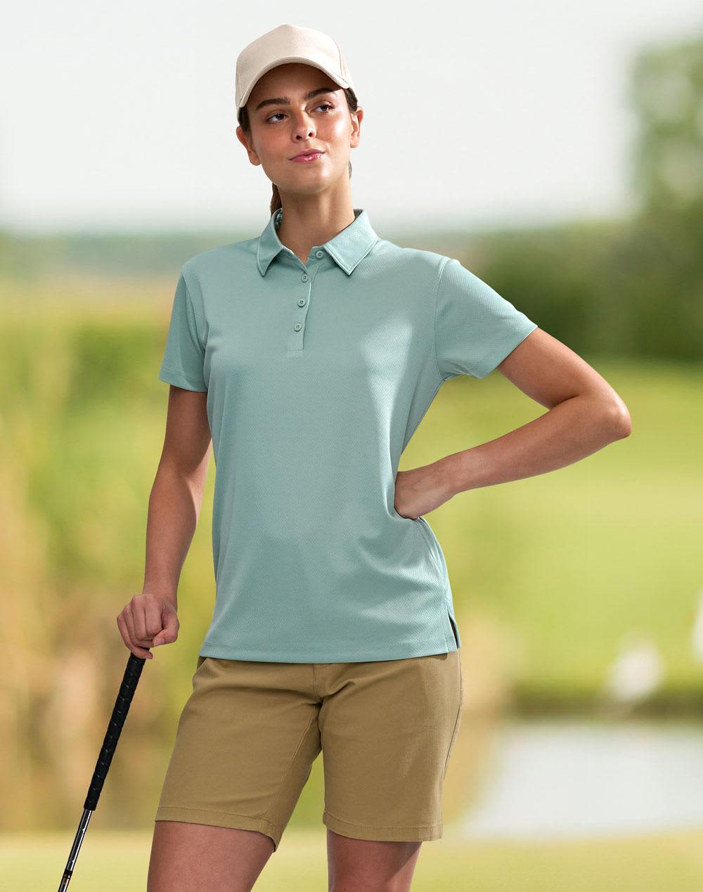 A teal ladies' sustainable jacquard knit short sleeve polo with a collar and side split. It has a logo on it. Ladies' Sustainable Jacquard Knit S/S Polo - Image 1