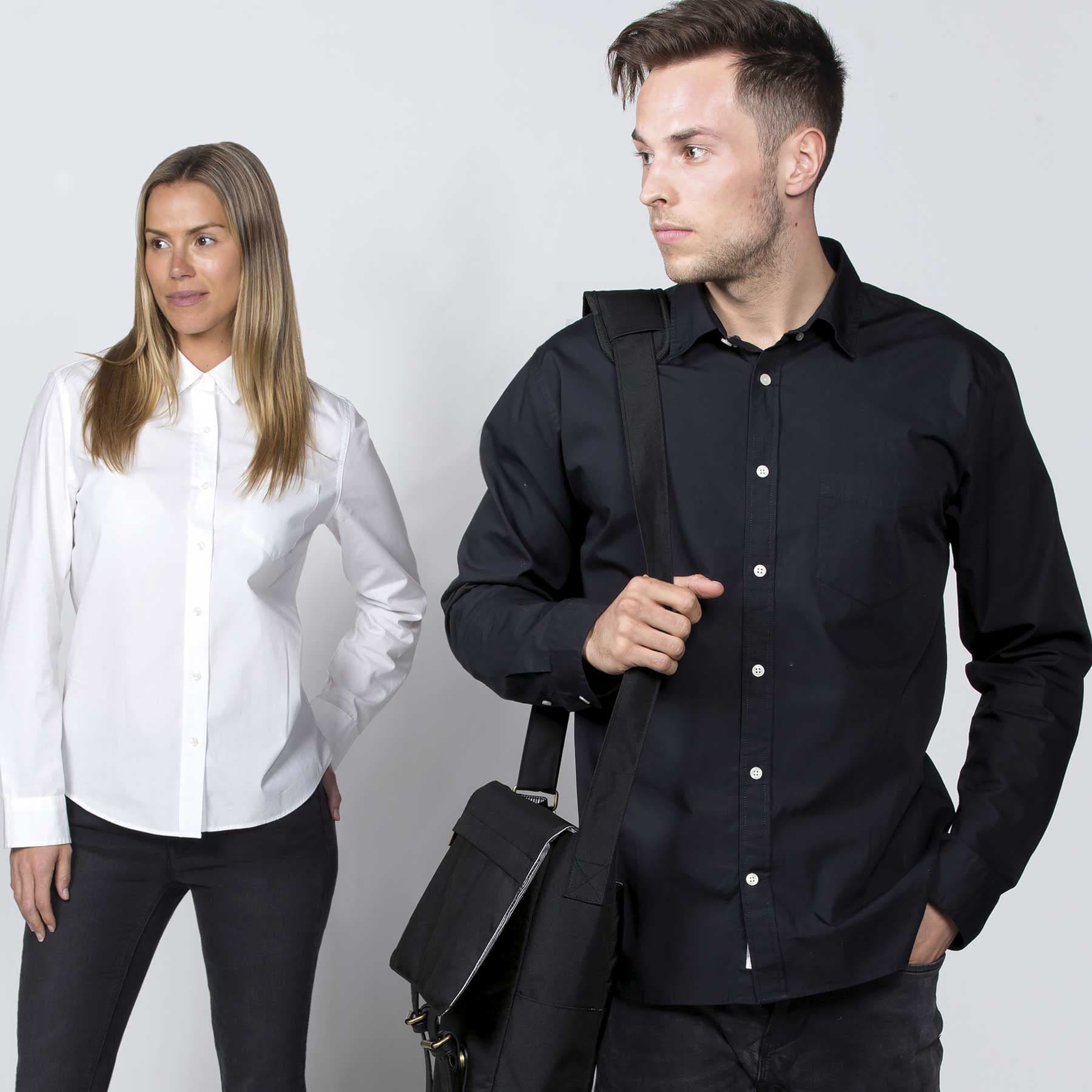 A woman in a white button-up shirt and a man in a black button-up shirt, both with stylish poses. smpli Womens Restore Shirt - Image 1