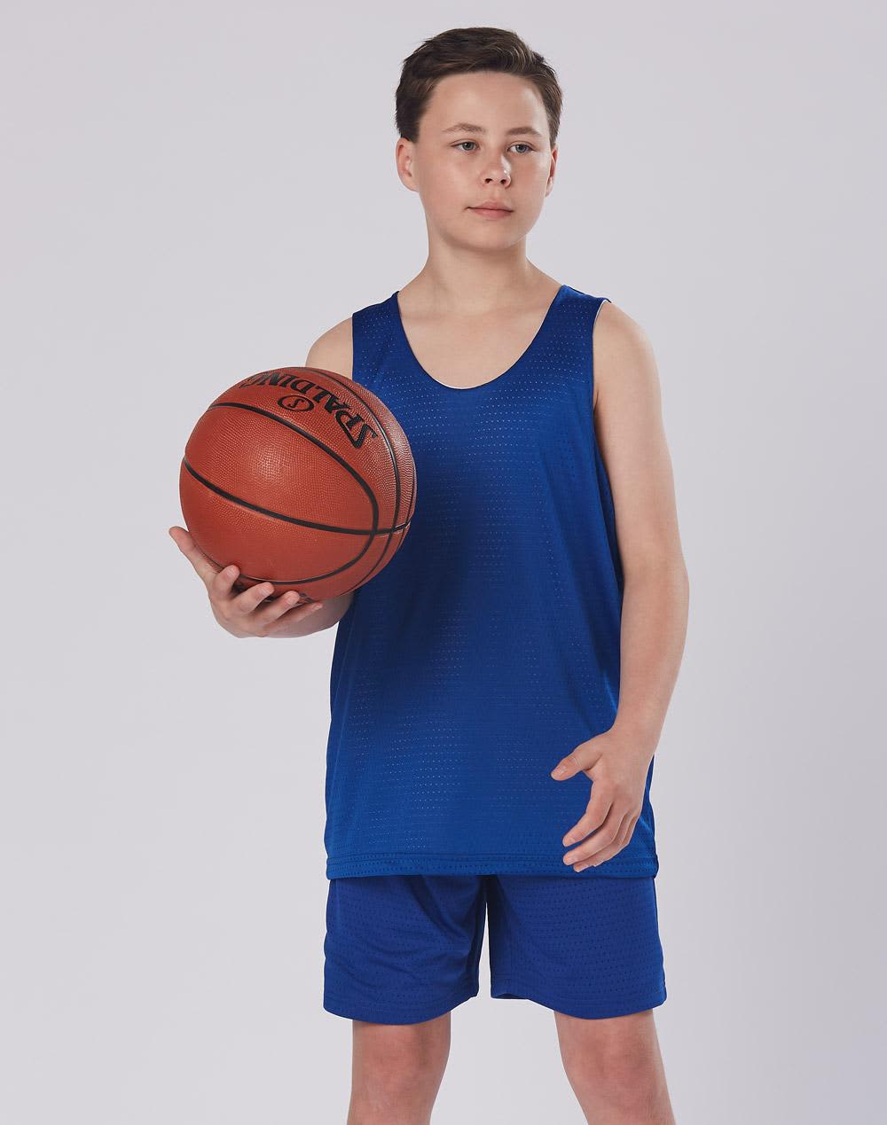 A child wearing blue basketball shorts and a matching tank top, holding a basketball. The outfit features a logo. Kid's Basketball Shorts - Image 1