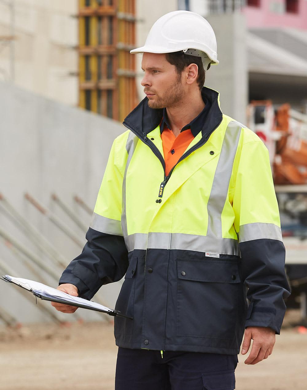 Hi-Vis two-tone rainproof safety jacket in yellow and navy, featuring 3M reflective tape, worn by a worker with a hard hat. Hi-Vis Two Tone Rain Proof Safety Jacket With 3M Tapes - Image 1