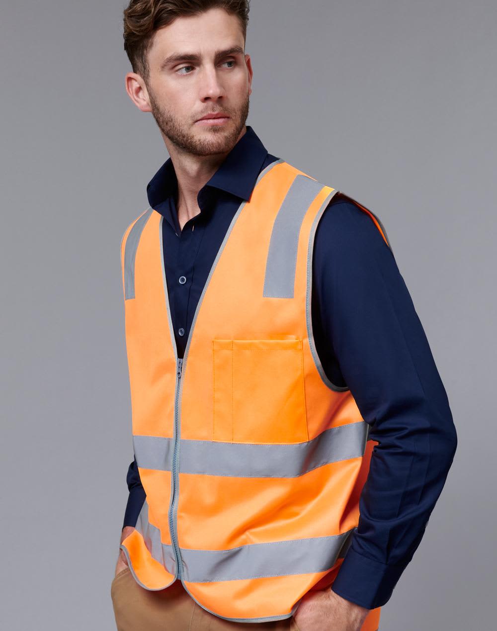 An orange safety vest with reflective stripes worn over a dark blue shirt, featuring a pocket and a logo. Biomotion Rail Safety Vest - Image 1