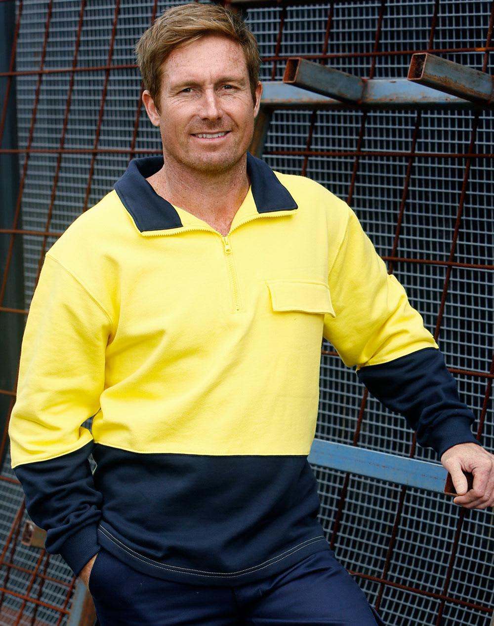 A man wearing a hi-vis two-tone yellow and navy cotton fleecy sweatshirt with a zip and pocket, posed against a metal backdrop. Hi-Vis Two Tone Cotton Fleecy Sweat - Image 1