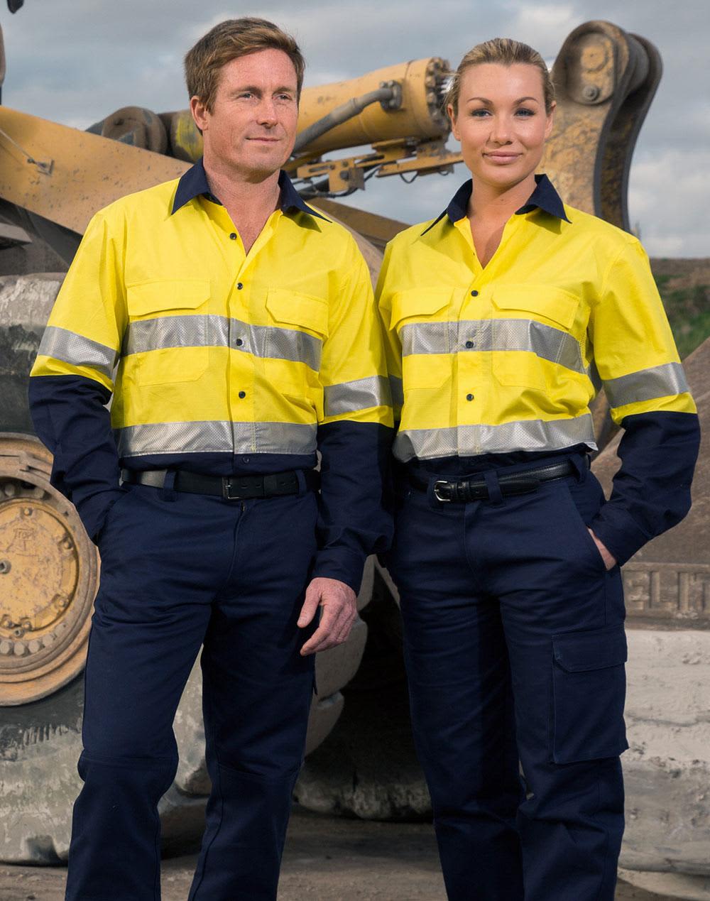 Two individuals wearing bright yellow long-sleeve shirts with reflective tape and navy pants, standing in an industrial setting. Hi-Vis Cotton Rip-Stop L/S Shirt 3M Tape - Image 1