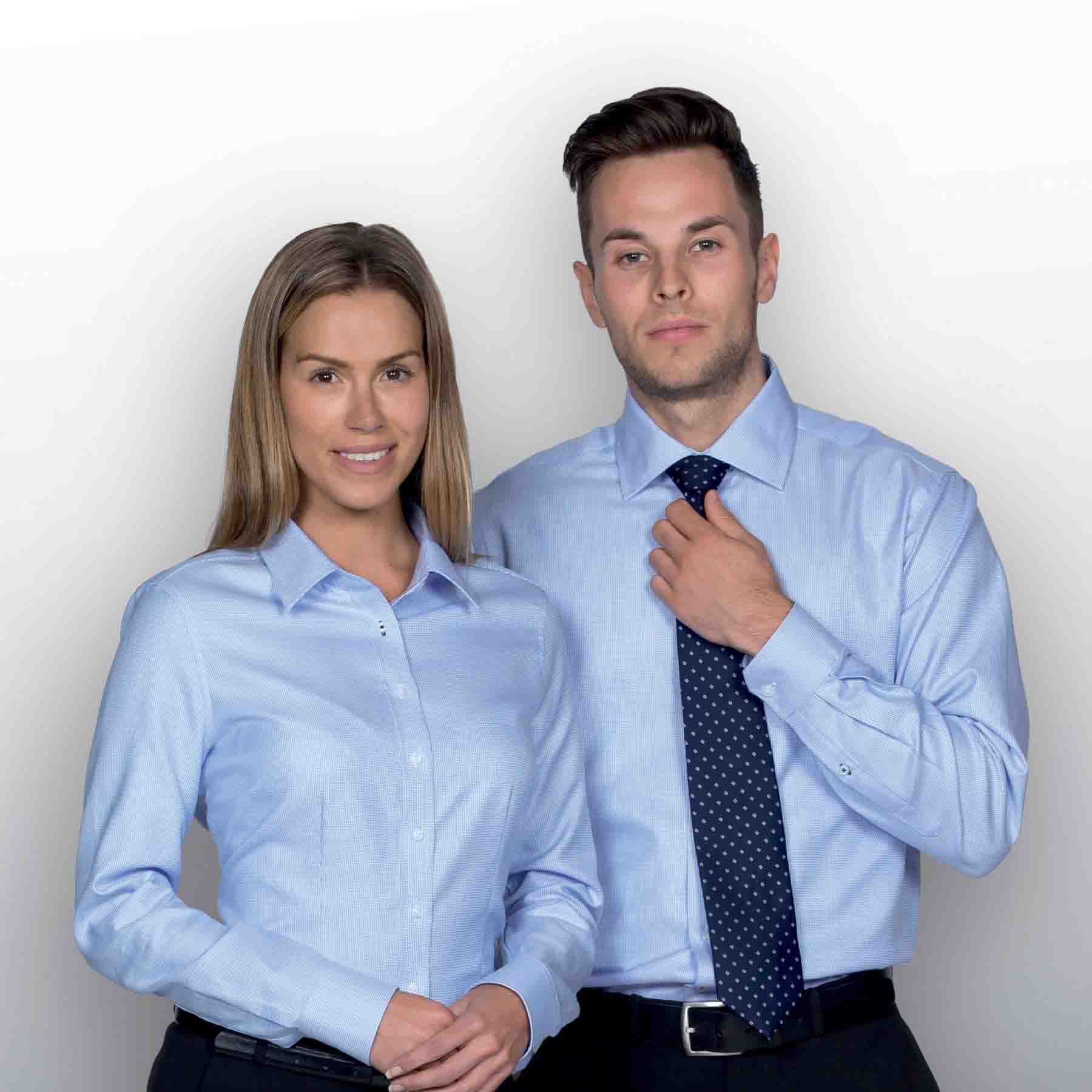 A light blue button-up shirt for women, featuring a collar, paired with a male model in a matching light blue shirt and tie. The Newport Shirt - Womens - Image 1