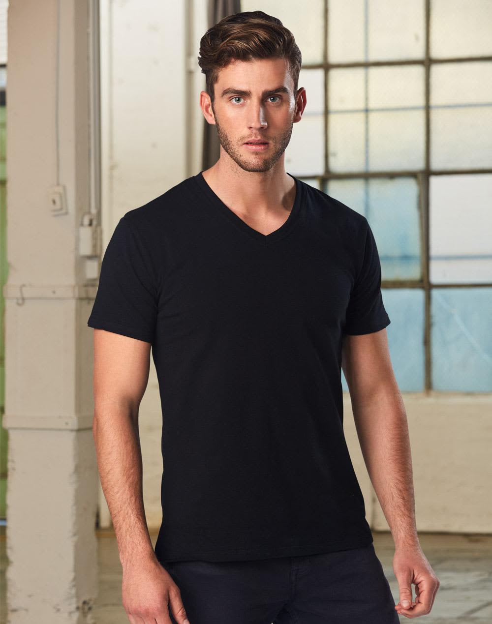 A men's black V-neck short sleeve tee, displayed on a model with a neutral background and natural lighting. Men's V-Neck Short Sleeves Tee - Image 1