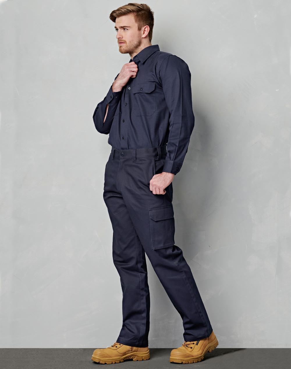 A man wearing navy cargo pants with a drill pant pocket on the leg, paired with a matching shirt and work boots. drill pant pockets on leg / stout fit - Image 1