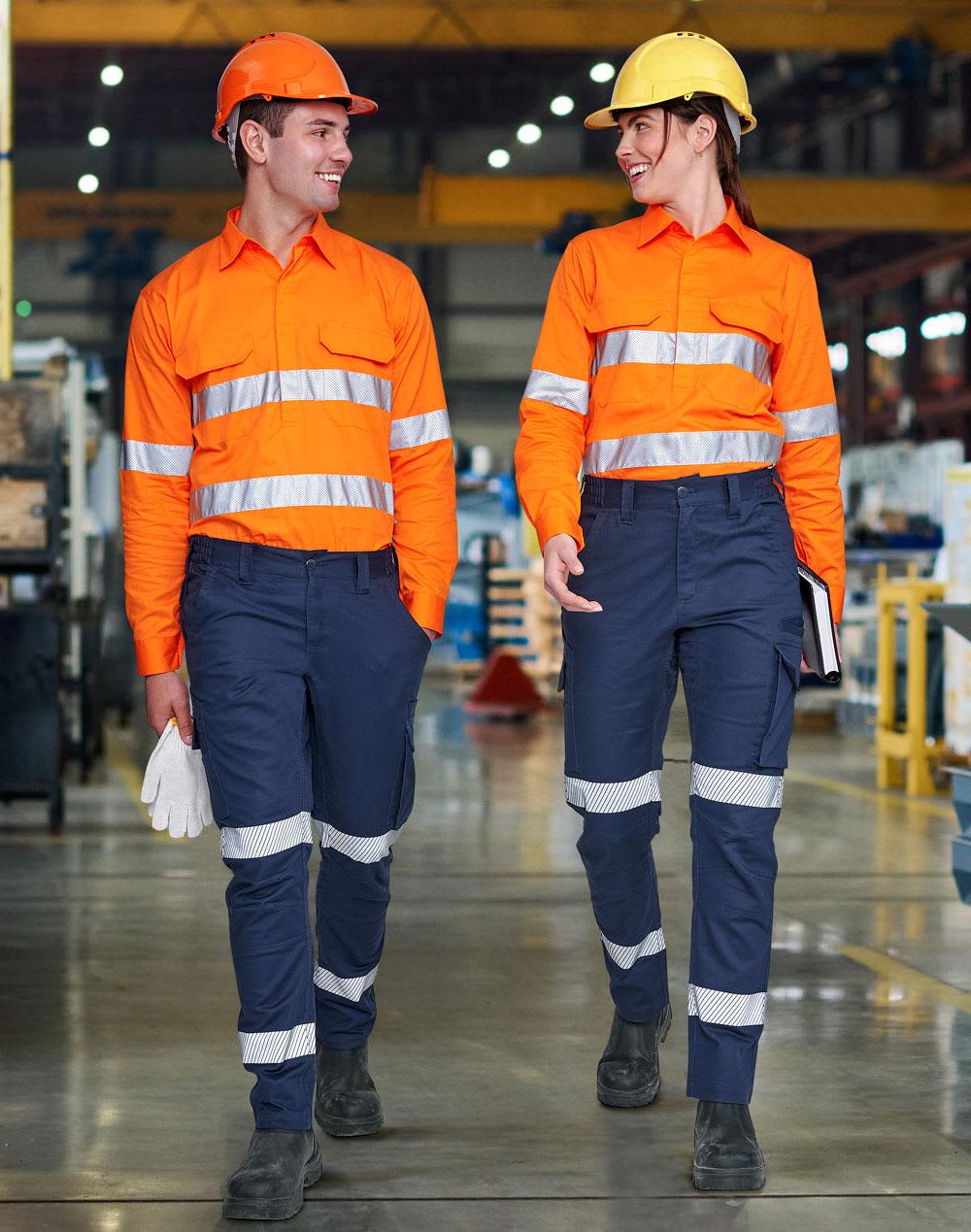 Two workers wear bright orange shirts and navy blue segmented work pants with reflective stripes in an industrial setting. Unisex Cotton Stretch Ripstop Segmented Work Pants - Image 1