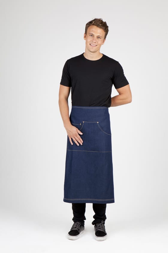 A man in a black t-shirt wears a long denim apron featuring a pocket and a logo. Long Waist Cotton/Denim Apron - Image 1
