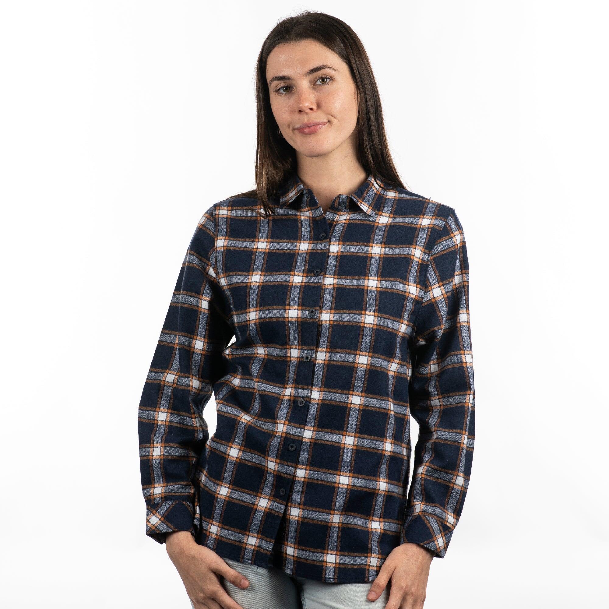 A model poses in a red and black plaid flannel button-up shirt with rolled sleeves. The shirt features a logo. Long Sleeve Yarn-Dyed Flannel Shirt - Image 1