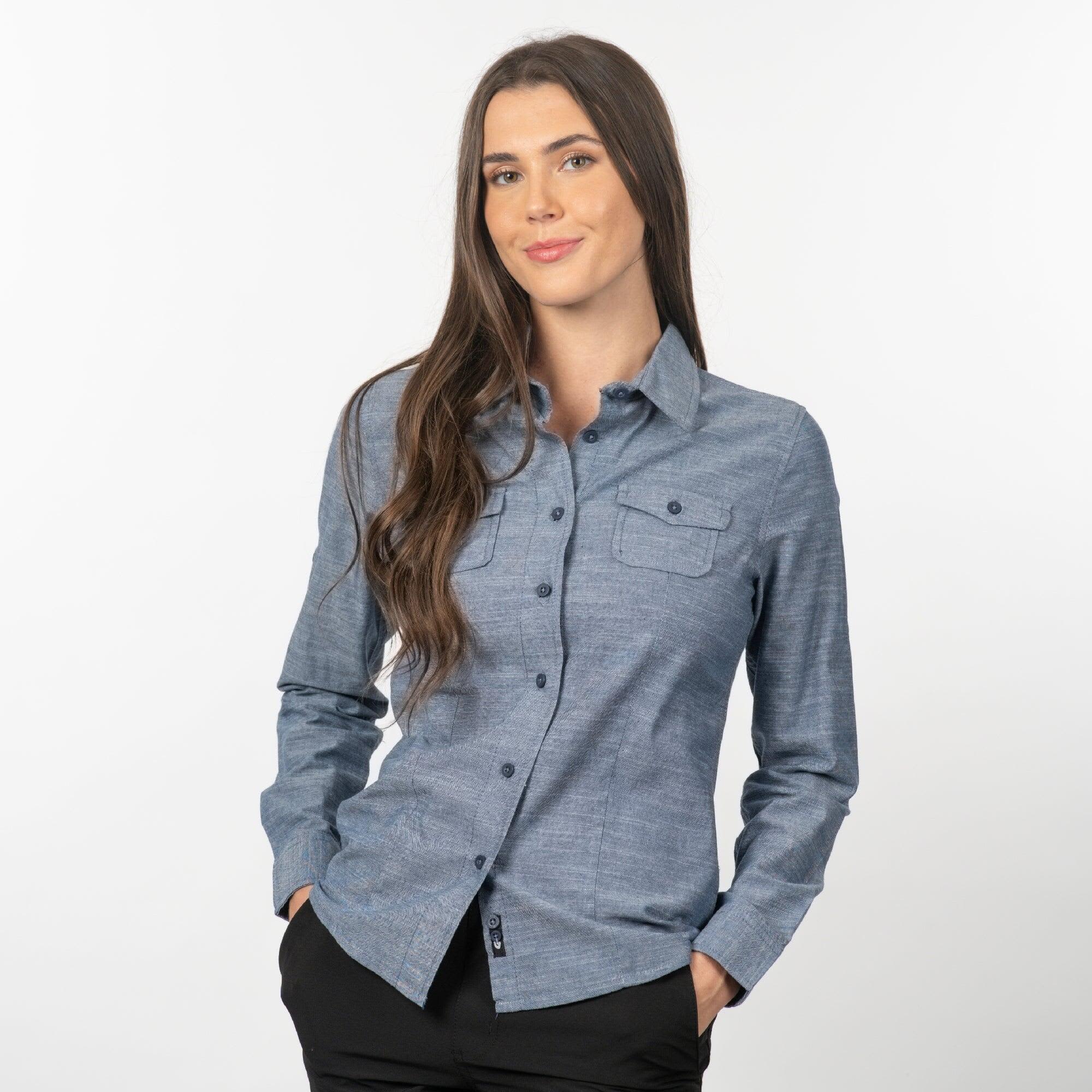 A long sleeve chambray button-up shirt in blue, featuring a chest pocket and a logo. Long Sleeve Chambray Shirt - Image 1