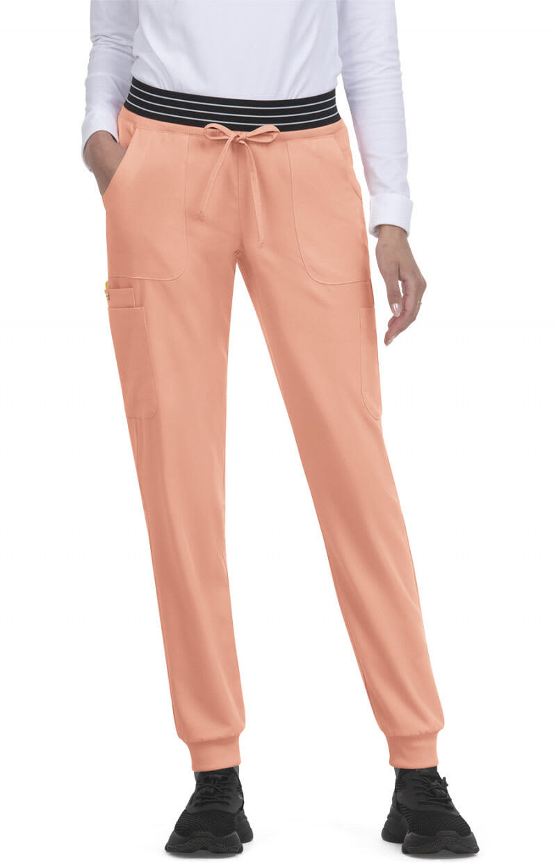 A pair of peach jogger pants with a black striped waistband and side pockets. Hollyhock Jogger - Image 1