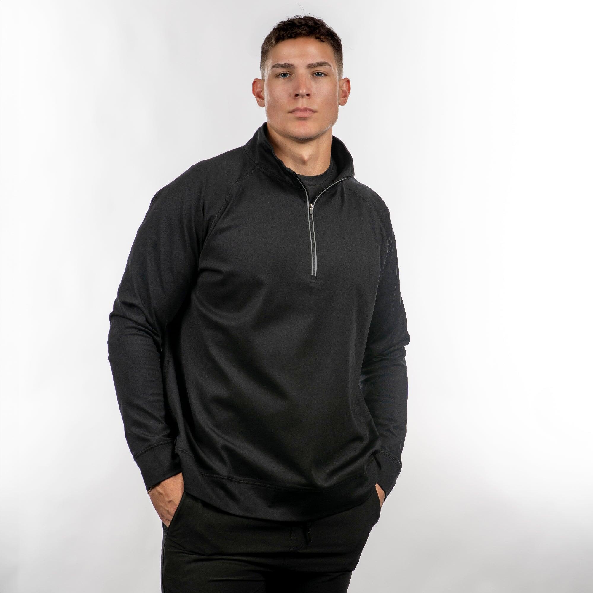 A black quarter-zip windbreaker featuring a stand-up collar and long sleeves, shown on a model against a light background. The Burn 1/4 Zip Windbreaker - Image 1