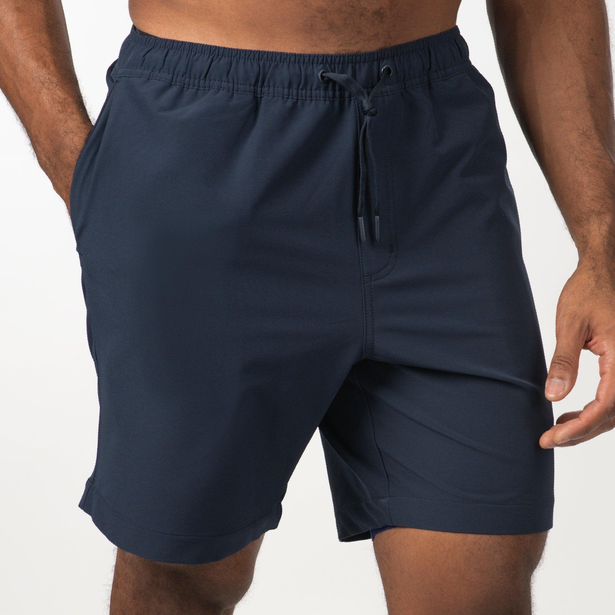 Navy sports shorts featuring an elastic waistband and a drawstring. Includes side pockets and a logo. The Perfect Shorts - Image 1