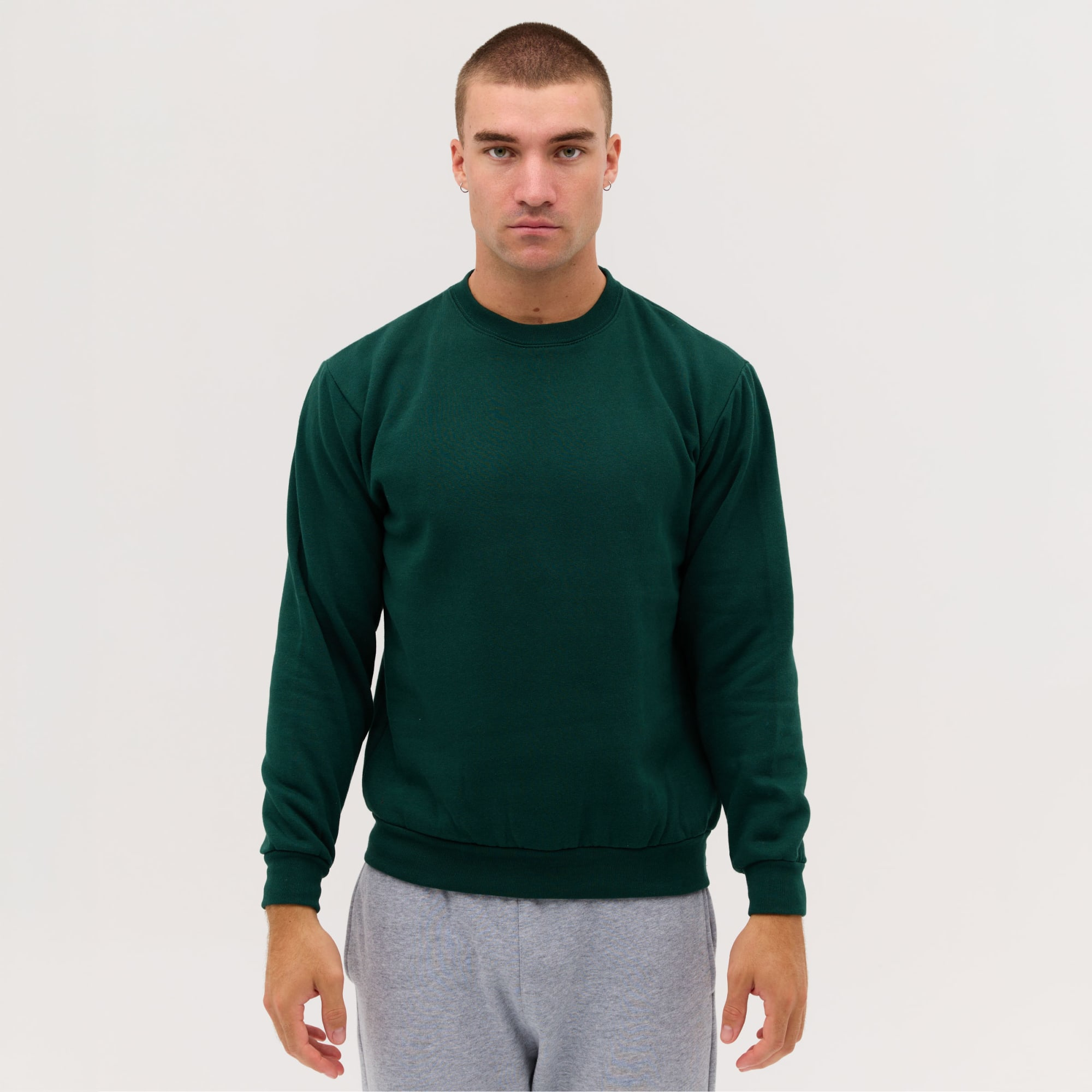 A green crew neck sweatshirt, worn by a model with a neutral expression, styled with grey sweatpants. Tacoma Sloppy Joe Crew - Image 1