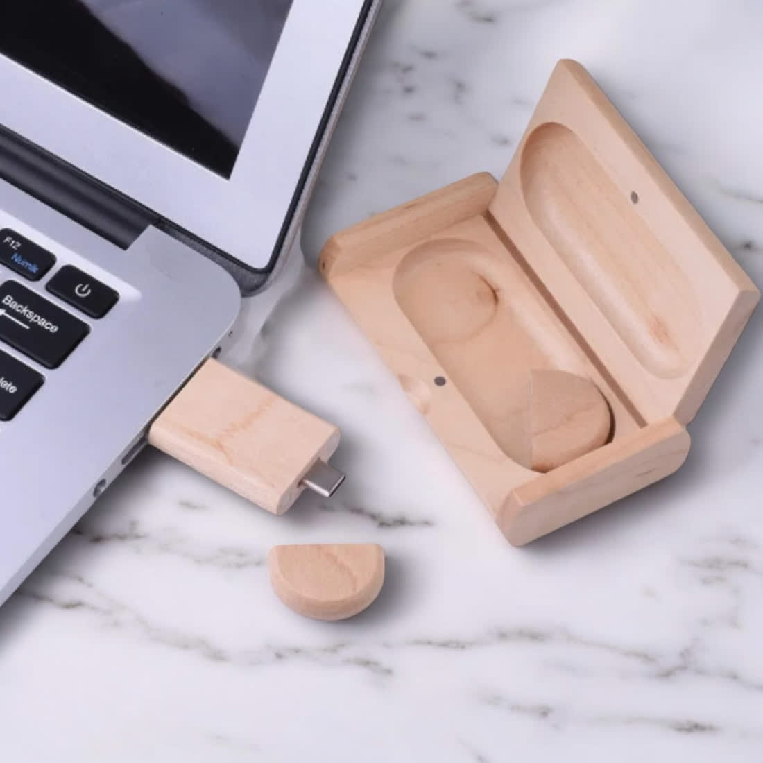 A wooden USB flash drive in a case, connected to a laptop, on a marble surface. The drive has a natural wood finish. Bengero Wooden Dual 16GB USB Flash Drive - Image 1