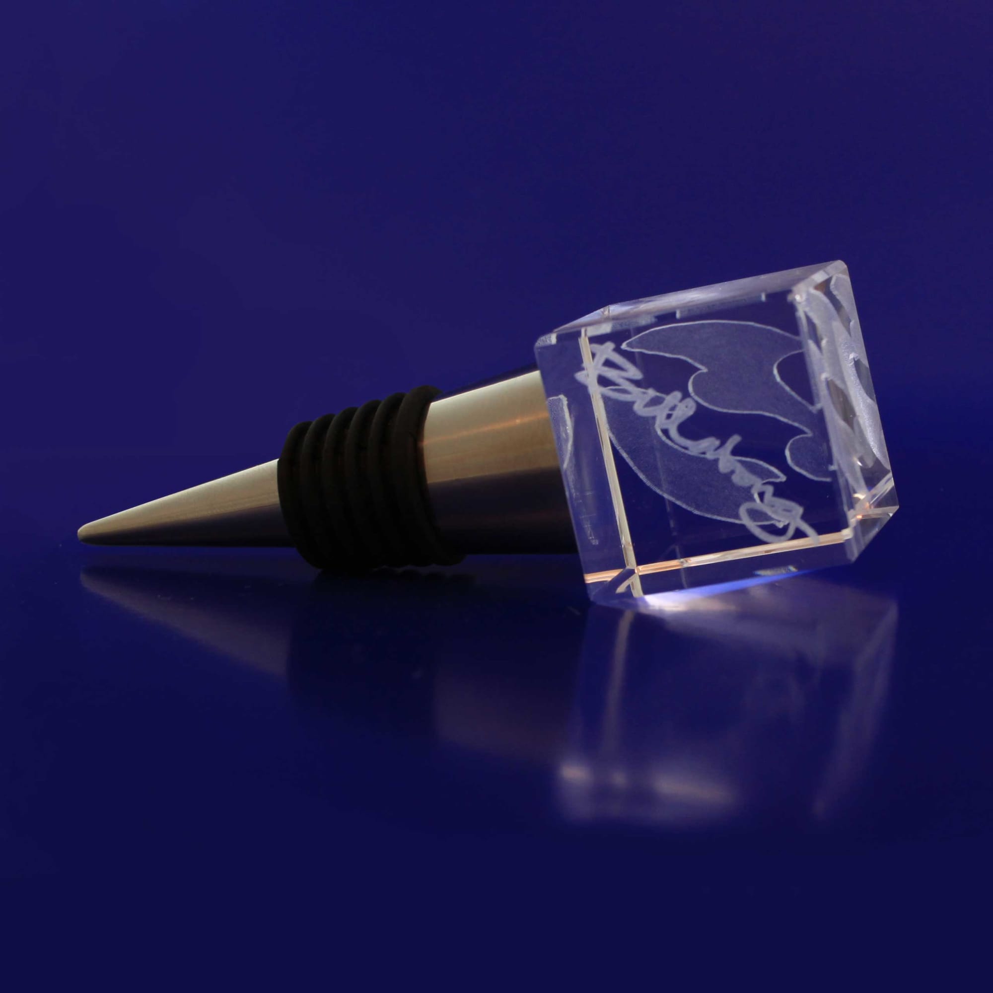 A drink bottle stopper made of clear crystal with a silver metal base, featuring an engraved design. 3D Crystal Bottle Stop - Image 1