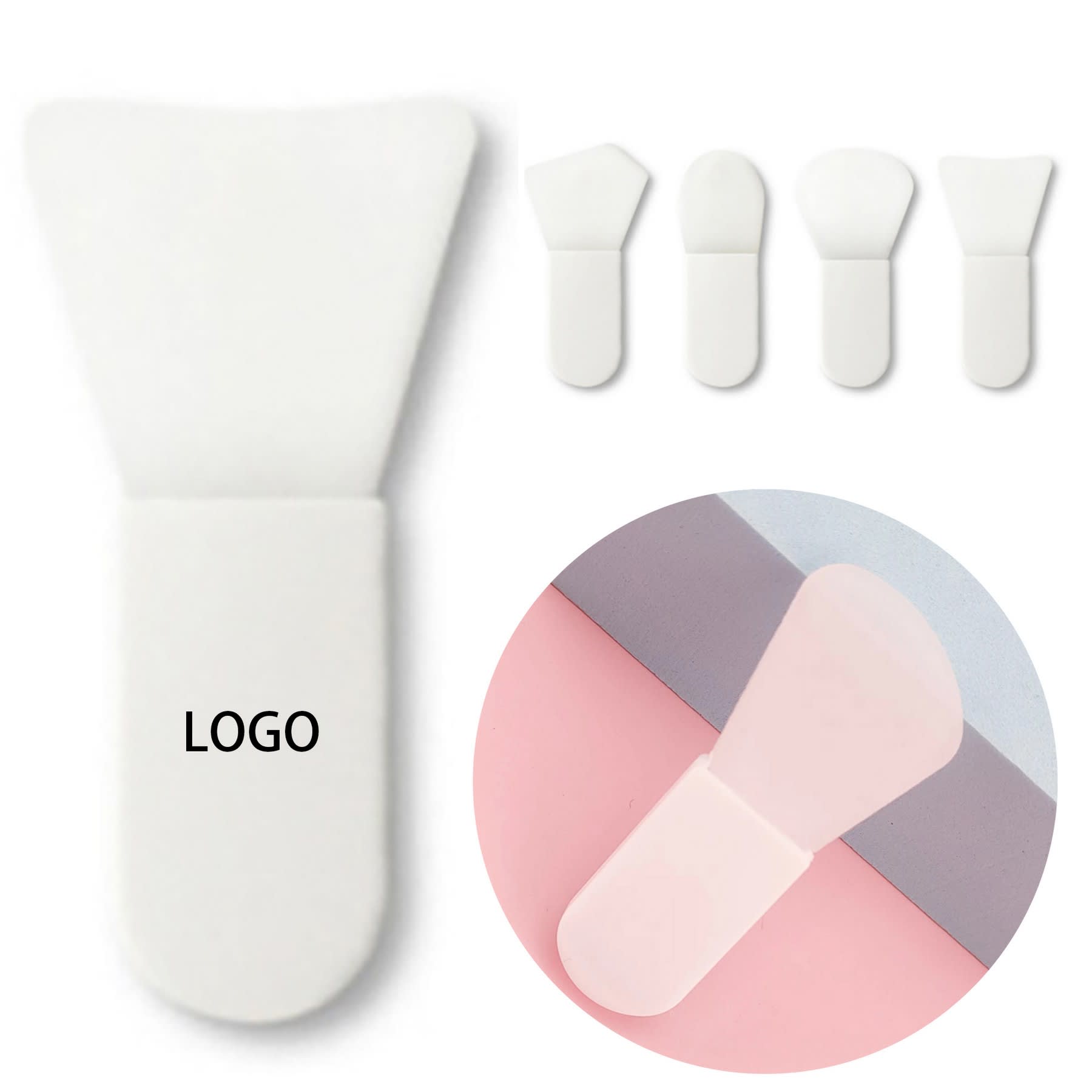 A silicone face mask brush in white, featuring a rounded tip and three additional similar brushes in a circular inset. Silicone Face Mask Brush - Image 1
