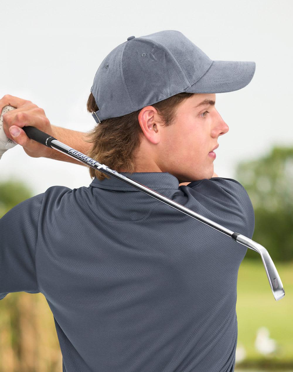 A young man wearing a grey jacquard texture 5-panel cap, holding a golf club in a lush outdoor setting. Jacquard Texture 5 Panel Cap - Image 1