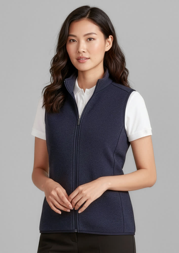 A woman wearing a navy zip-front vest over a white shirt, featuring a zipped front and a standing collar. Womens Nova Zip Front Vest - Image 1