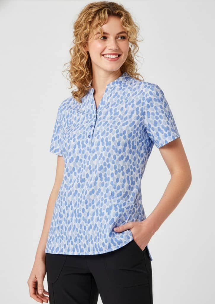 A blue tunic with a stardust print, featuring short sleeves and a collar, displayed on a smiling model. Womens Florence Stardust Print Tunic - Image 1