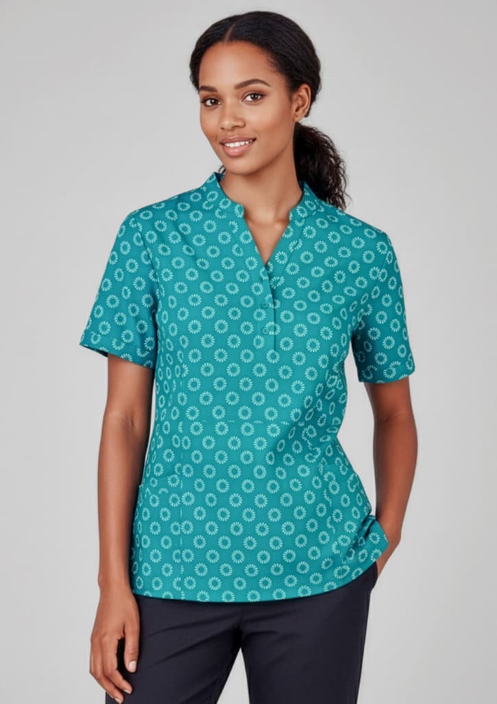 A teal tunic featuring a circular daisy print, designed with short sleeves and a relaxed fit. Includes a logo. Womens Florence Daisy Print Tunic - Image 1