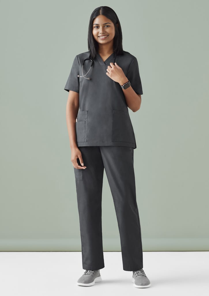 A model wearing black Women's Tokyo Scrub Pant paired with a matching top, featuring pockets and a logo. Womens Tokyo Scrub Pant - Image 1